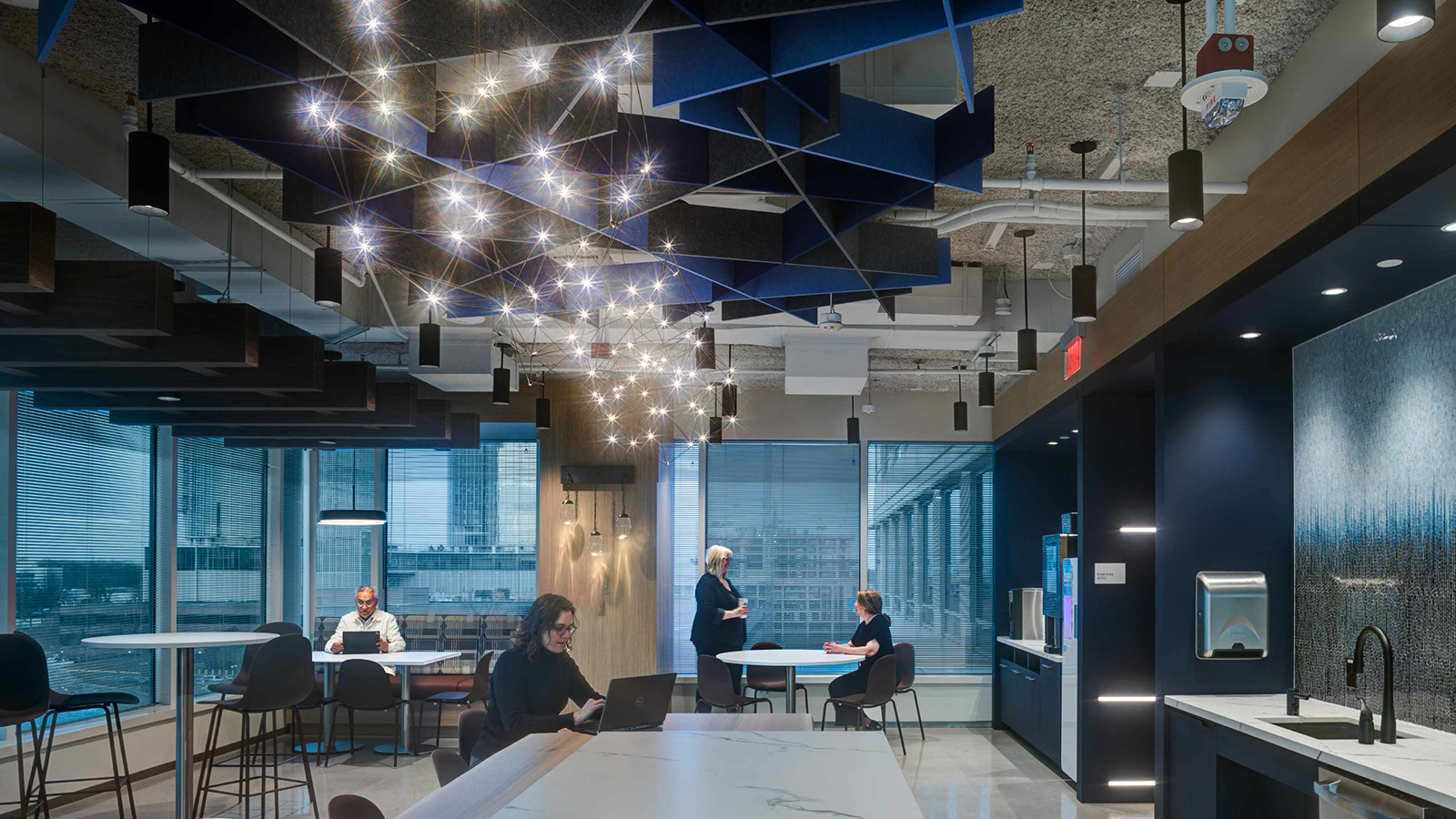 People sitting in a office communal area sitting and discussing with one another