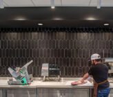 Butchers Club interior of man slicing meat at counter