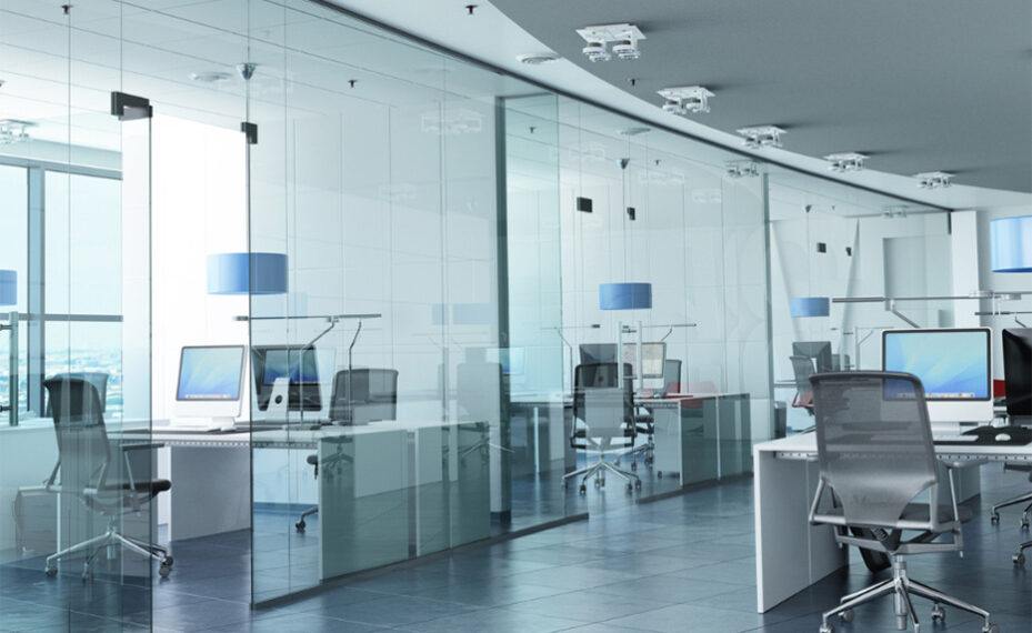Workplace with enclosed glass offices with desks and computers