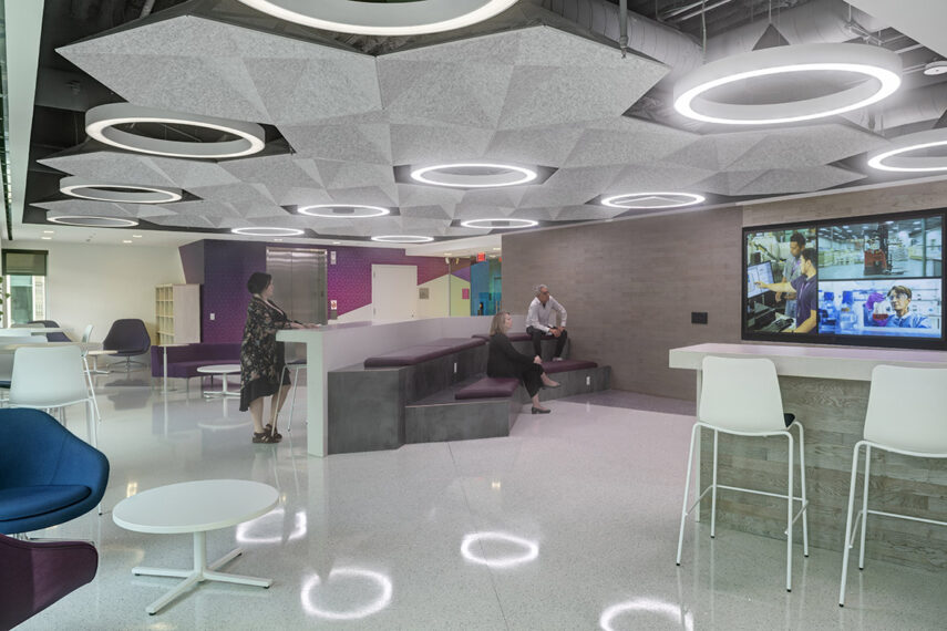 Leidos Annex presentation room in break area with people sitting and standing