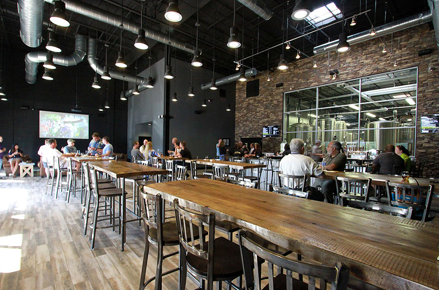 Jailbreak Brewing Company interior with tables and chairs and people